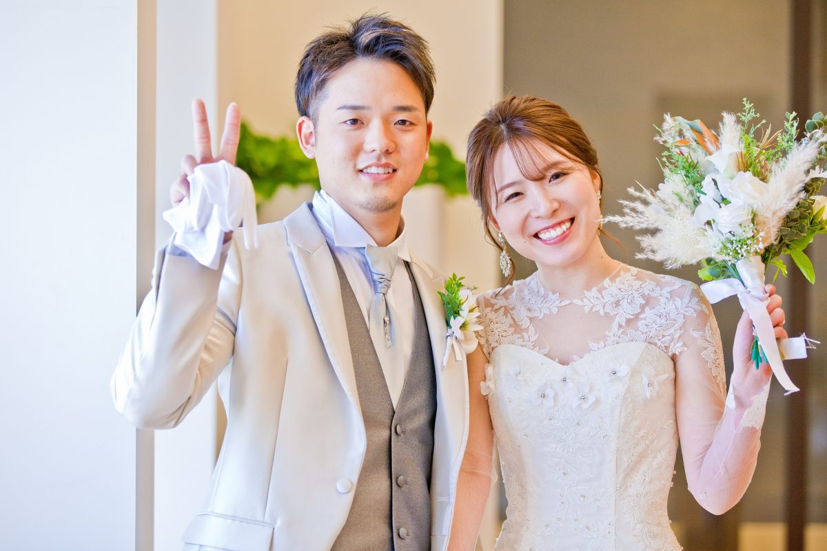 新郎新婦様が結婚式当日笑顔でポーズを取ってくれているフォト